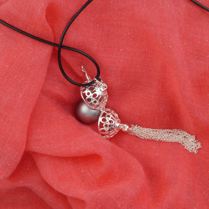 Bola petites bulles présenté à plat sur un tissu rose légèrement pailleté. Il est ouvert pour que l'on puisse voir ses deux faces et il repose sur une perle grise anthracite.