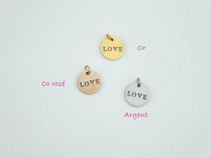 Médaille "Love" présentée sous ses 3 versions : or, or rosé et argent. Petit pendentif rond dans lequel est découpé le mot LOVE en majuscules.